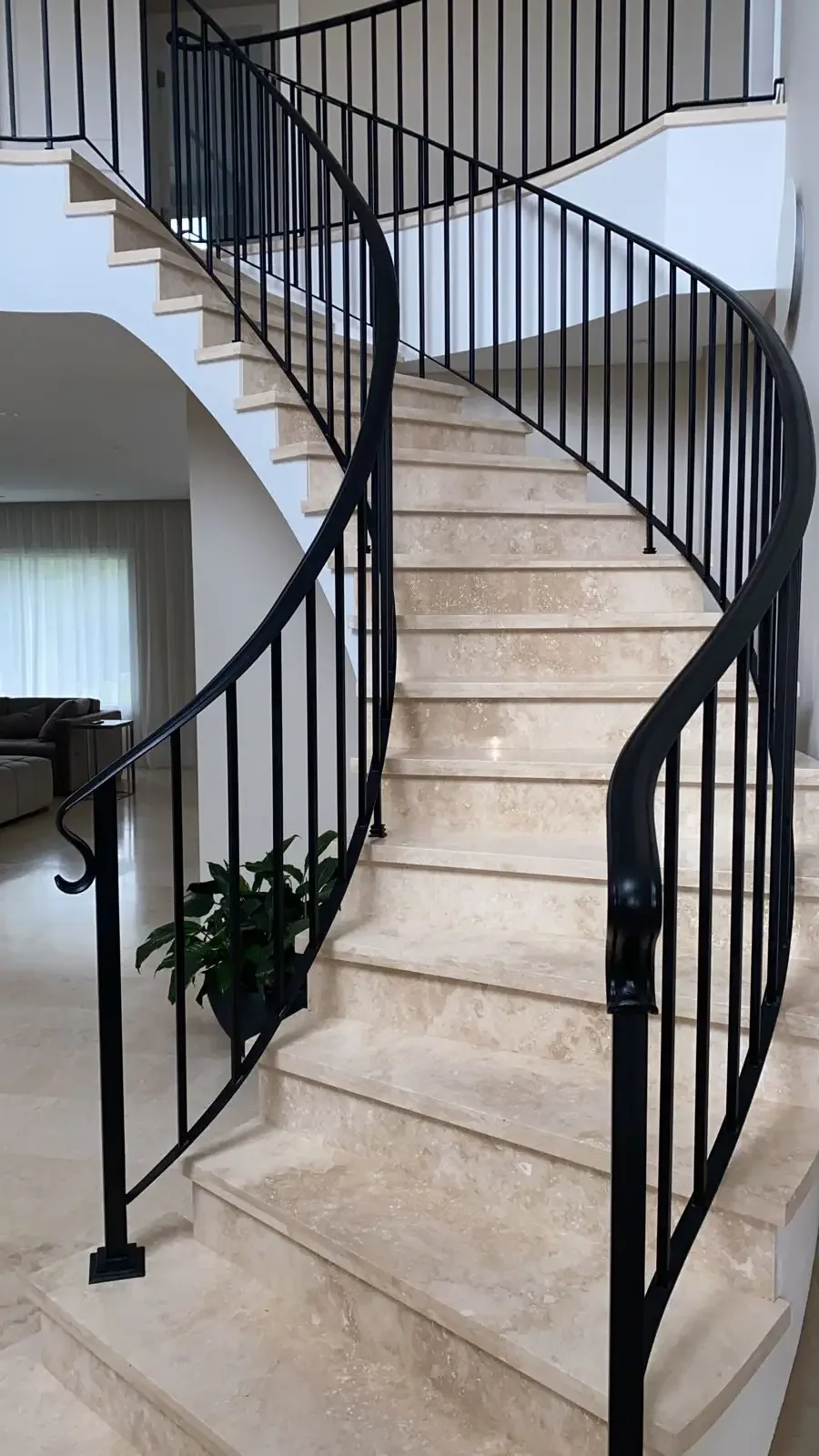 Escalera curva interior con baranda de hierro de líneas contemporáneas