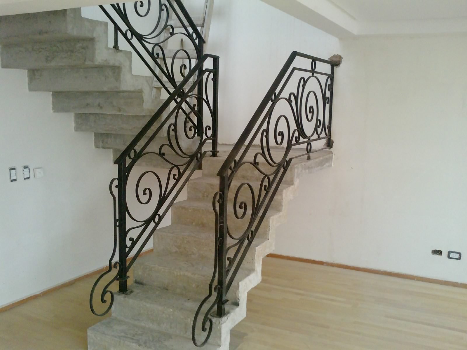 Escalera de doble tramo con estructura y barandas de hierro