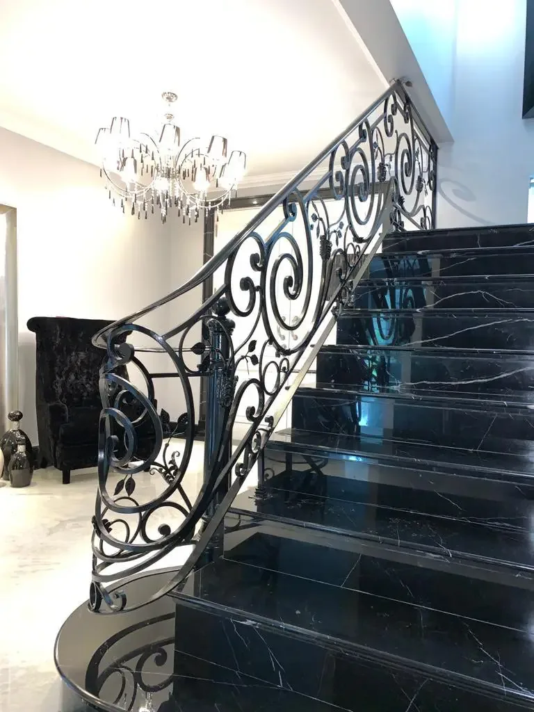 Escalera interior negra con baranda ornamental