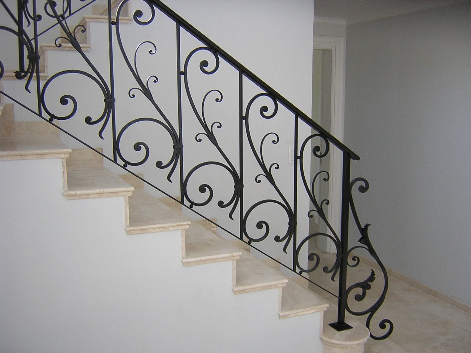Escalera recta con baranda ornamental de hierro
