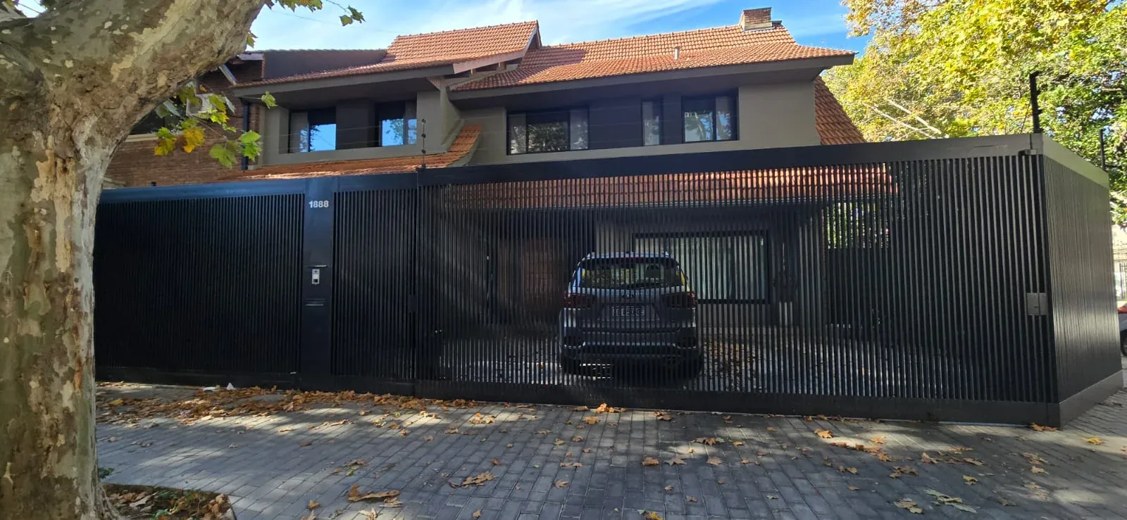 Fachada residencial con herrería moderna de líneas verticales