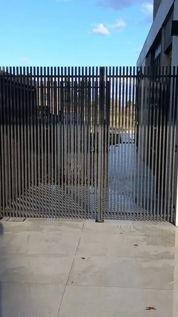 Portón y cerramiento de herrería moderna con lamas verticales
