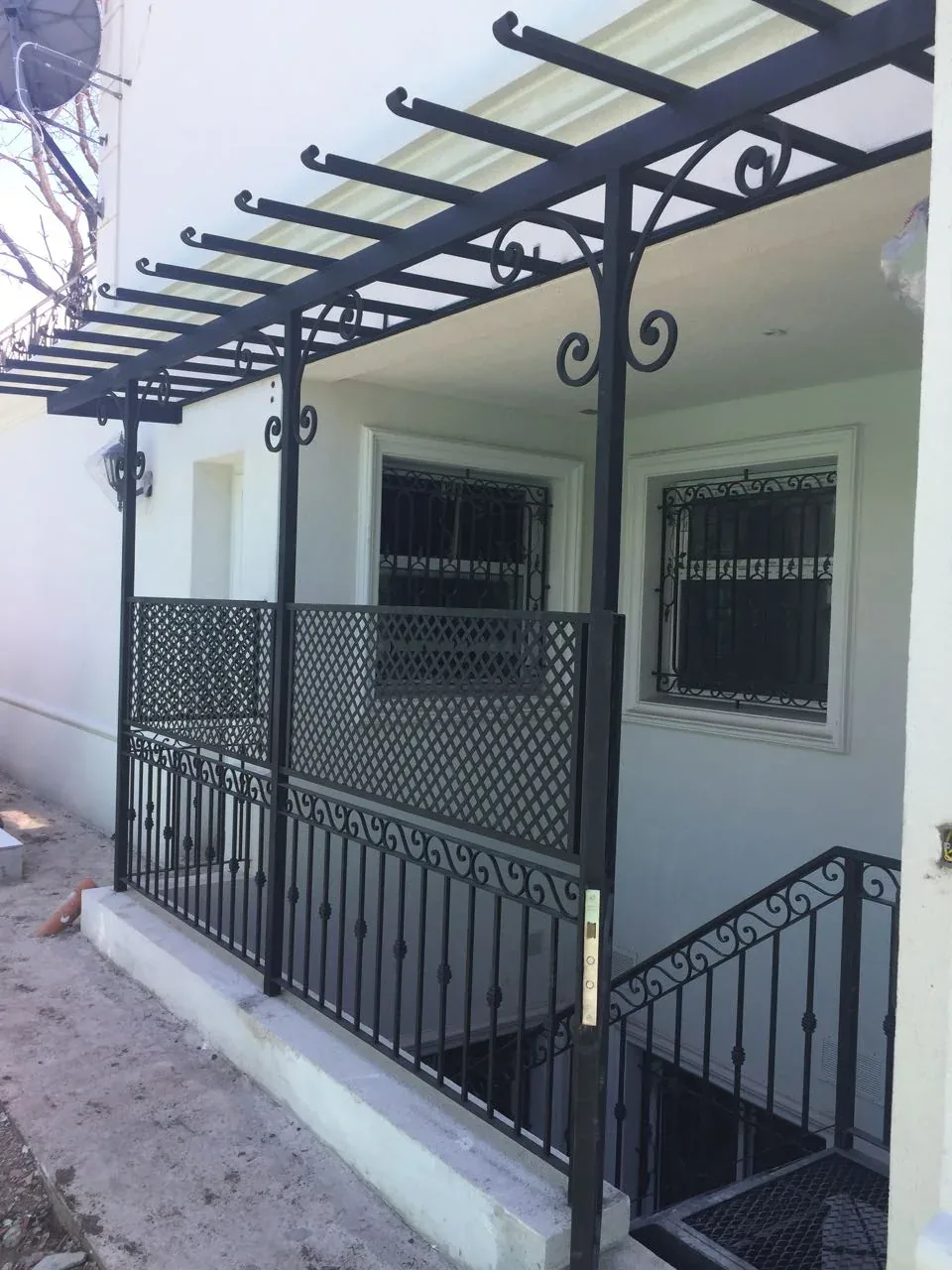 Pérgola y alero de hierro en acceso exterior