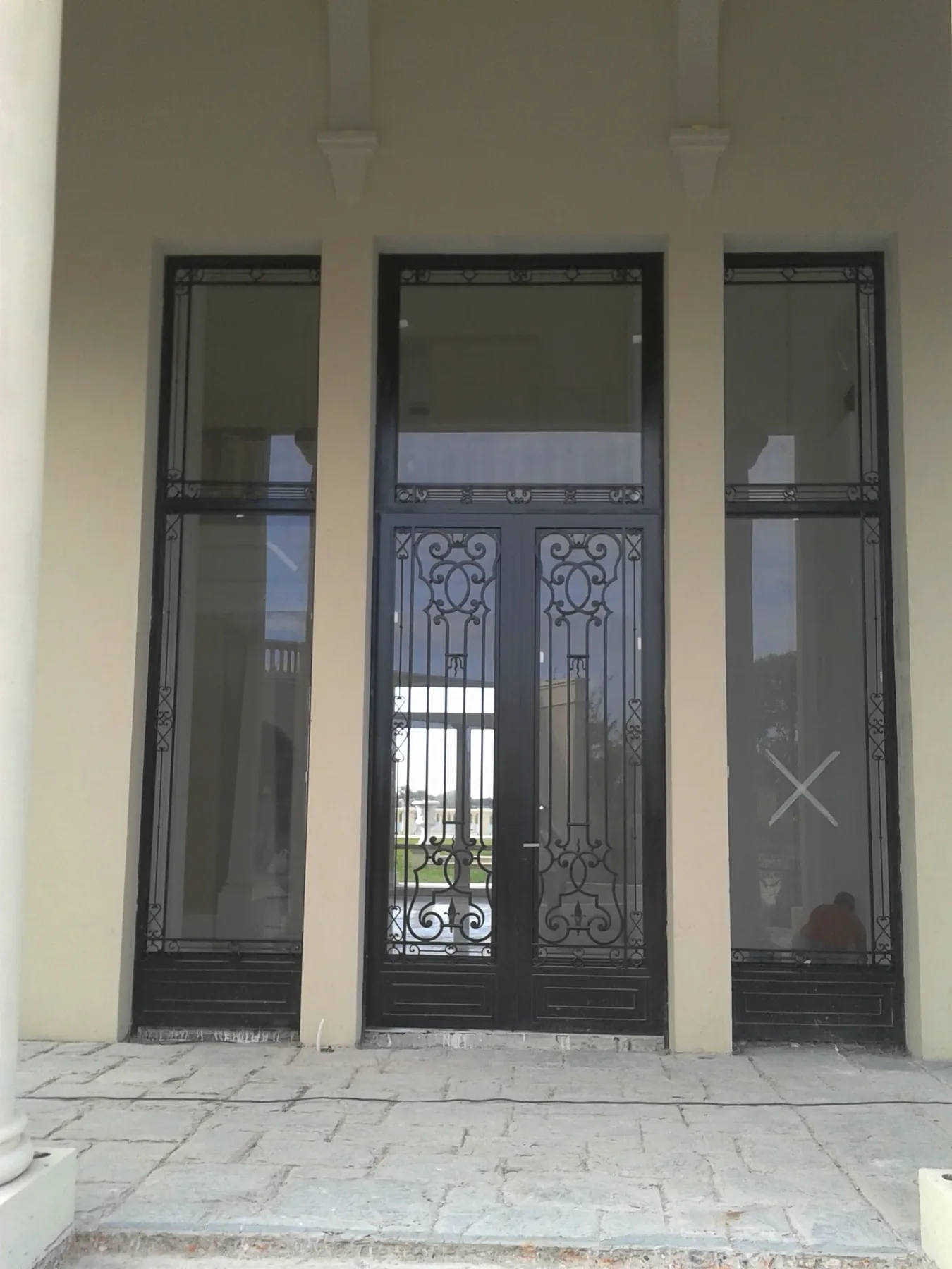 Puerta de hierro con paños laterales vidriados
