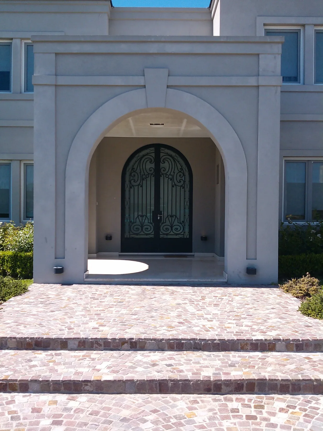 Puerta de hierro ornamental en fachada residencial clásica