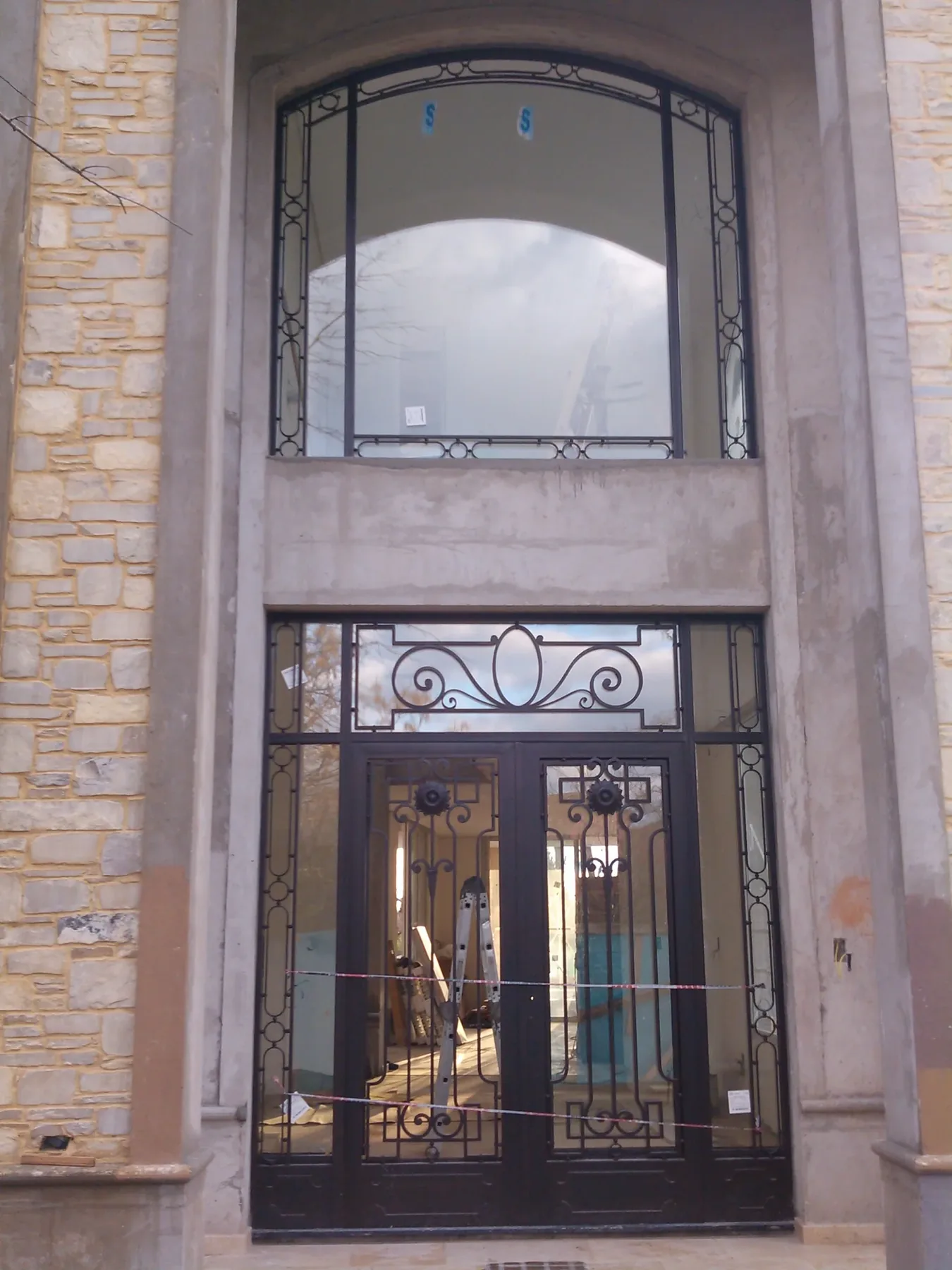 Portada de doble altura con puerta de hierro