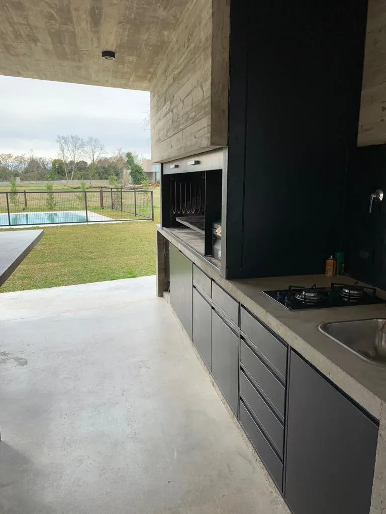 Quincho con muebles metálicos y cerramiento de parrilla a medida